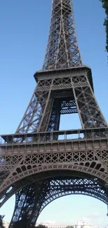 Eiffel Tower against clear blue sky with greenery.