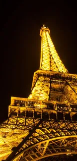 Eiffel Tower illuminated at night with golden lights.