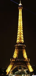 Eiffel Tower illuminated at night against a dark sky.