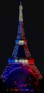 Eiffel Tower lit up with vibrant red, white, and blue lights at night.