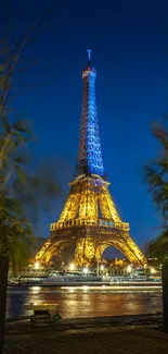 Eiffel Tower illuminated at night in Paris with a clear dark blue sky.