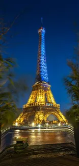 Eiffel Tower glowing at night with vibrant blue sky backdrop.