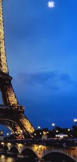 Eiffel Tower illuminated against a deep blue night sky with urban lights below.