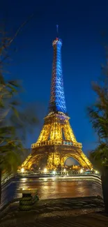 Eiffel Tower at night with illuminated lights against a deep blue sky.