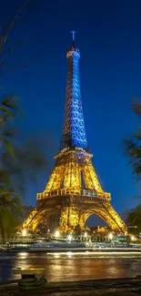 Eiffel Tower lit up at night with blue sky and greenery.