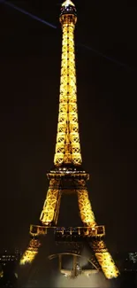 Eiffel Tower illuminated at night against a dark sky.