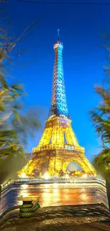 Eiffel Tower glowing at night with a blue sky.