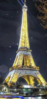 Eiffel Tower illuminated at night with reflections on the Seine River.