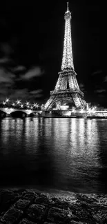 Black and white Eiffel Tower night view with Seine reflection.