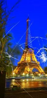 Eiffel Tower at night with glowing lights and vibrant blue sky.