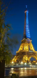 Eiffel Tower illuminated at night against a dark blue sky.