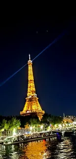 Eiffel Tower glowing at night by the Seine, under a starry sky.