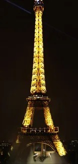 Illuminated Eiffel Tower at night in Paris, glowing against the dark sky.