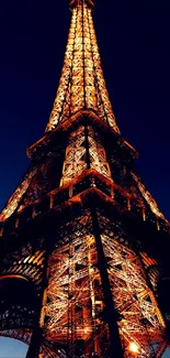 Illuminated Eiffel Tower against a dark blue night sky.