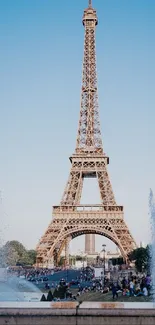 Mobile wallpaper of the Eiffel Tower in Paris with a blue sky backdrop.