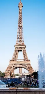 Eiffel Tower against a vivid blue sky with fountains in the foreground.