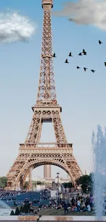 Eiffel Tower under a blue sky with clouds and birds.