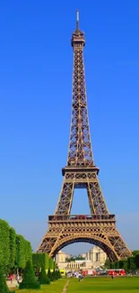 Eiffel Tower under a vibrant blue sky with green trees, perfect for a phone wallpaper.