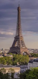 Eiffel Tower with dramatic sky and lush greenery in Paris.