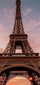 Eiffel Tower at sunset with a pink sky backdrop.