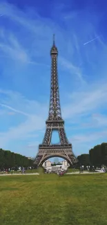 Eiffel Tower under a clear blue sky with lush green surroundings.