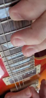 Close-up of hand playing an electric guitar.