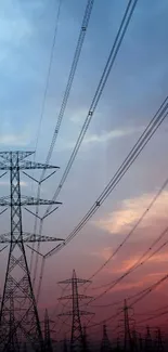 Silhouetted electric towers against a dramatic sunset sky.