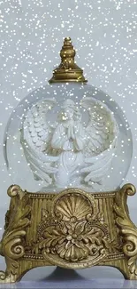 Angel snow globe with golden base and intricate details.