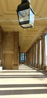 Elegant hallway with columns and ceiling lantern casting shadows.