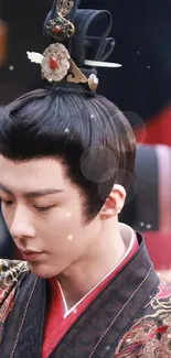 Man in traditional Asian attire with ornate headpiece.