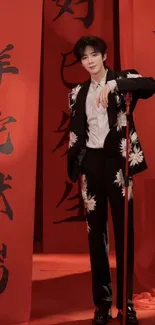 Person in elegant floral outfit with red backdrop and calligraphy.