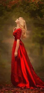 Woman in a striking red dress stands in a serene, autumn forest setting.