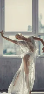 Ballet dancer posing gracefully by a sunlit window.