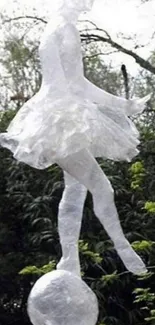 Elegant white ballerina sculpture in outdoor setting.