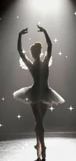 Silhouette of a graceful ballerina in dramatic lighting on stage.