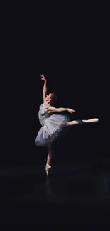 Ballerina performing on a dark stage, displaying elegance and grace.