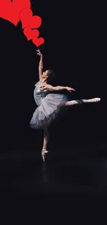 Ballet dancer with red hearts, dark background.