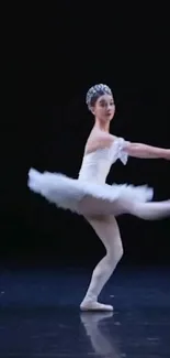 Graceful ballet dancer performing on a dark stage.