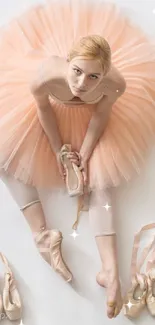 Ballerina in peach tutu with ballet shoes on white background.