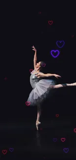 Graceful ballerina performing with heart motifs on dark background.