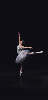 Elegant ballet dancer posing on a dark stage, perfect mobile wallpaper.