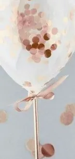 Elegant rose gold balloon with polka dots and ribbon.