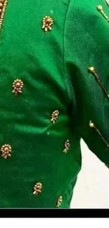 Green blouse with intricate beaded design on sleeve.