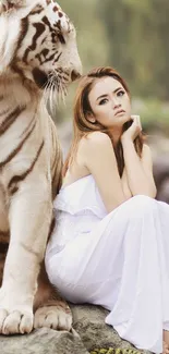 Woman in white sitting with a majestic white tiger in a serene natural setting.