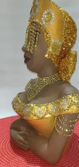 Bejeweled golden sculpture on red base.