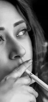 Black and white portrait of a woman smoking, showcasing sophistication and style.