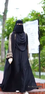 Elegant woman in black attire walking outdoors.