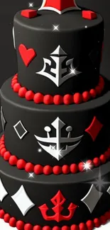 Three-tier black cake with red and white decorations.