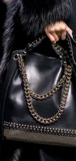 Stylish black handbag with metallic chains and detailing, emphasizing elegance.