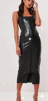 Stylish woman in a black leather dress standing against a neutral background.